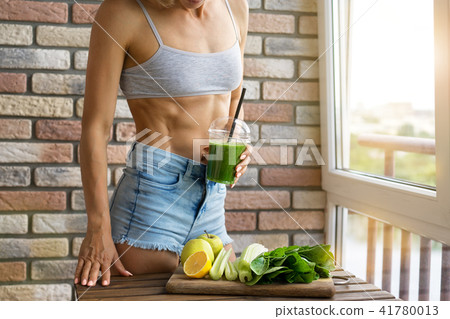 Fit woman drinking vegetable Green detox smoothie. raw food diet Fit woman drinking vegetable Green detox smoothie. raw food diet 41780013