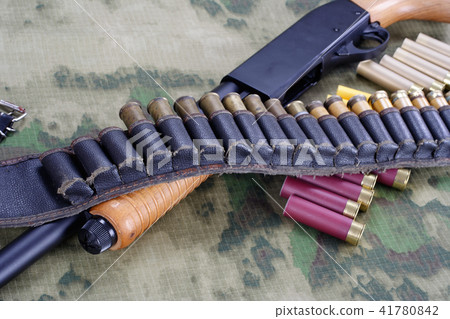 pump shotgun with ammunition on camouflaged pump shotgun with ammunition on camouflaged 41780842
