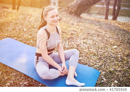 Girl in Lotus pose on yoga Mat in the Park. Girl in Lotus pose on yoga Mat in the Park. 41785930