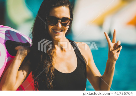 happy female carrying rubber ring near pool and slides happy female carrying rubber ring near pool and slides 41786764