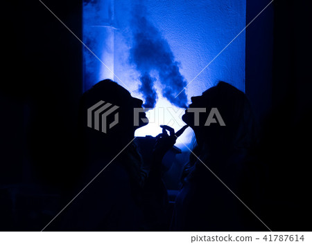 Two girls release smoke in the dark Two girls release smoke in the dark 41787614