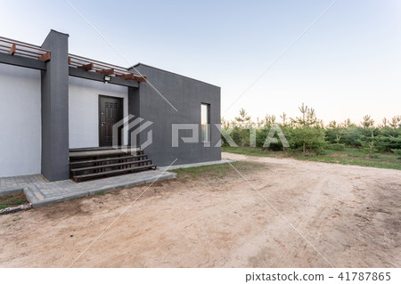Side view of an open veranda in front of a modern forest cottage. Pine young forest under the sunset 41787865