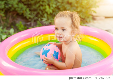 Children playing in inflatable baby pool. Children playing in inflatable baby pool. 41787996