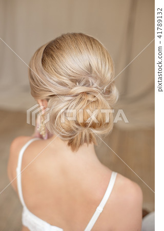 Rear view of female hairstyle middle bun with blond hair 41789132