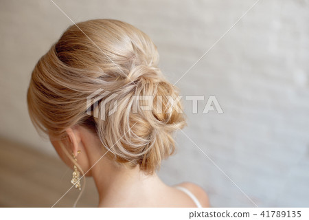 Rear view of female hairstyle middle bun with blond hair Rear view of female hairstyle middle bun with blond hair 41789135