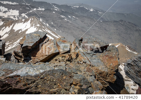 Mountain goat resting on top of mountain peak 41789420