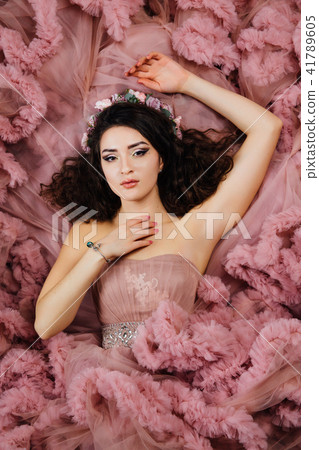 Luxurious sexy girl in an evening cloudy dress lies on the floor. Luxurious sexy girl in an evening cloudy dress lies on the floor. 41789605