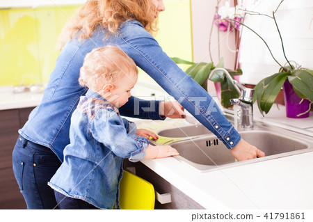 Mother with a baby boy washing dishes 41791861