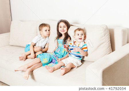 Photo of beautiful children on white modern couch. 41792034