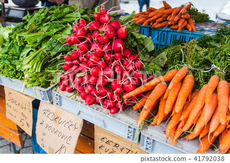 Carrots, radishes and spinach on the counter. 41792038