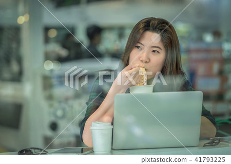 Portrait of asian businesswoman in casual suit eating noodles with happiness action in rush hour at the desk beside the glass in modern office, Business work hard concept Portrait of asian businesswoman in casual suit eating noodles with happiness action in rush hour at the desk beside the glass in modern office, Business work hard concept 41793225