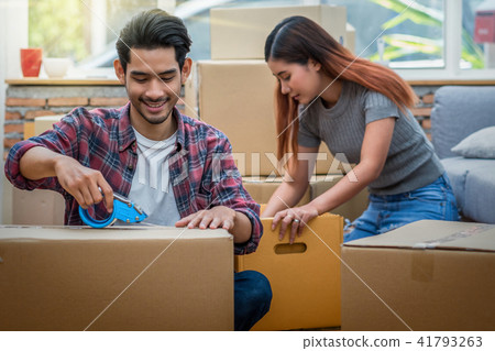 Asian young couple packing the big cardboard box for moving in new house, Moving and House Hunting concept, Asian young couple packing the big cardboard box for moving in new house, Moving and House Hunting concept, 41793263