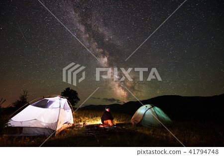Woman tourist resting at night camping under starry sky and Milky way Woman tourist resting at night camping under starry sky and Milky way 41794748