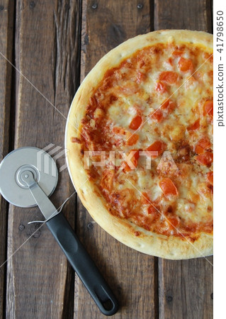 Frozen pizza margherita to eat at home and a pizza cutter 41798650