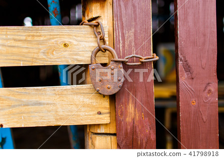 Old padlock attached to the wooden wall of shed 41798918