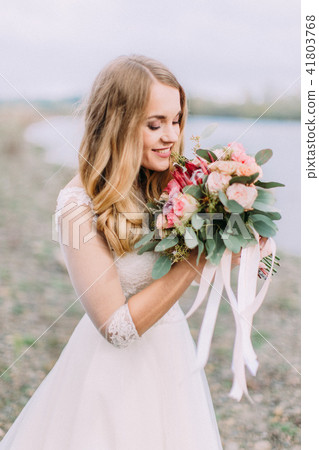 Side portrait of the bride smelling the wedding bouquet. The beach location. Side portrait of the bride smelling the wedding bouquet. The beach location. 41803768