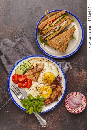 Fried eggs with bacon and a sandwich with meat Fried eggs with bacon and a sandwich with meat 41804194