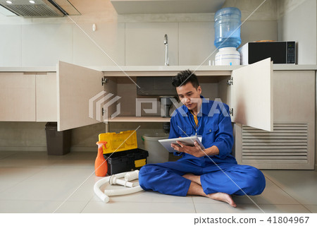 Plumber checking tablet computer Plumber checking tablet computer 41804967