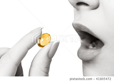 Close-up shot of woman brings the pill to her mouth. 41805472