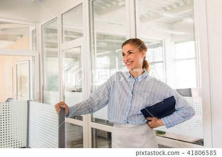 Smiling woman with clipboard in office Smiling woman with clipboard in office 41806585