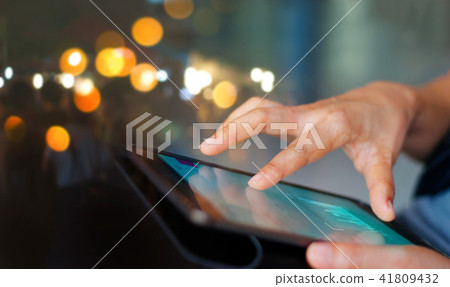 Man using tablet at night time, lighting bokeh Man using tablet at night time, lighting bokeh 41809432
