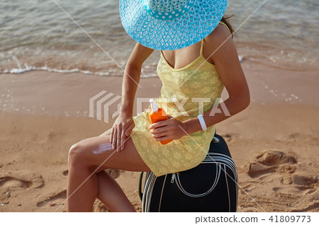 Sunscreen and beautiful female feet in the summer pool, the concept of protecting the skin 41809773