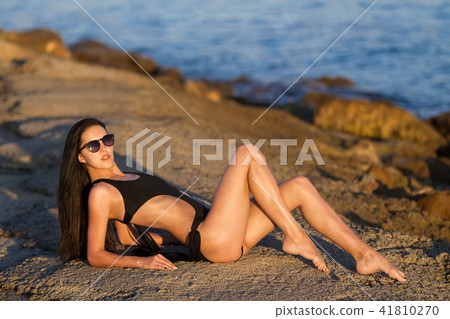 beauty woman with perfect tanned body near an ocean 41810270