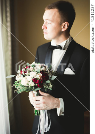 Young handsome man relaxing at his apartment in a hotel after business meeting 41811287
