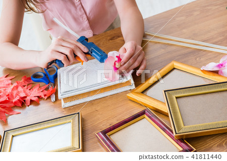Woman decorating picture frame in scrapbooking concept 41811440
