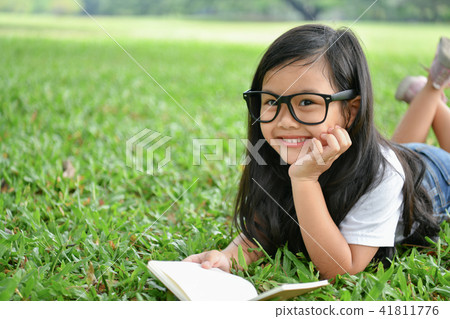 Education Concepts. The girl is reading a book in the garden. Be Education Concepts. The girl is reading a book in the garden. Be 41811776