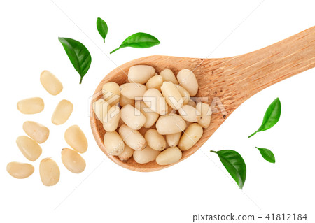 Shelled cedar pine nuts in wooden spoon isolated on white background. Top view. Flat lay Shelled cedar pine nuts in wooden spoon isolated on white background. Top view. Flat lay 41812184