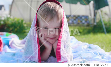 A little boy lying on the lawn on a hot summer day. The child is fun and active to spend their A little boy lying on the lawn on a hot summer day. The child is fun and active to spend their 41812245