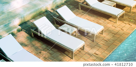 Blank white loungers near pool on brick surface mockup Blank white loungers near pool on brick surface mockup 41812710