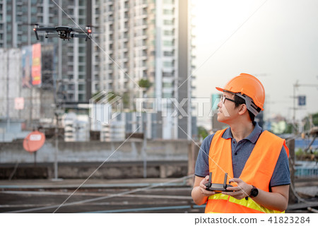 Asian engineer flying drone over construction site 41823284