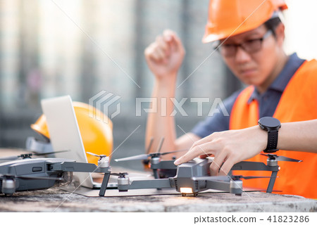 Asian man using drone and laptop for site survey 41823286