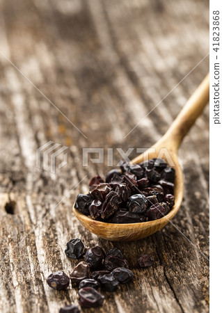 Spoon of barberry on a wooden background. Spoon of barberry on a wooden background. 41823868