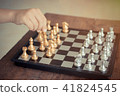 Kid hold chess pieces in chess game . 41824545
