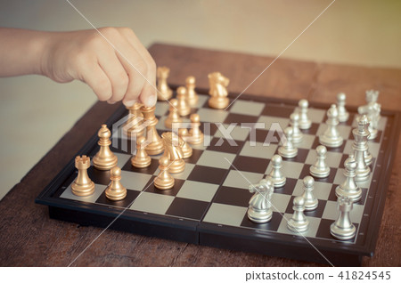Kid hold chess pieces in chess game . Kid hold chess pieces in chess game . 41824545