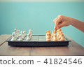 Kid hold chess pieces in chess game. 41824546
