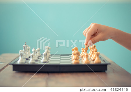 Kid hold chess pieces in chess game. 41824546