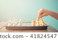 Kid hold chess pieces in chess game . 41824547