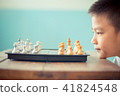 asian boy think or plan about chess game. 41824548