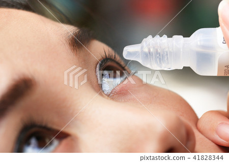 Teen girl drips into the patient eye medication. Teen girl drips into the patient eye medication. 41828344
