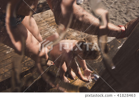 Mom is washing her daughter in beach shower. - Stock Photo [41828463] - PIXTA