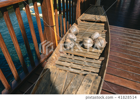 Wooden canoe with old coconuts,  41828514