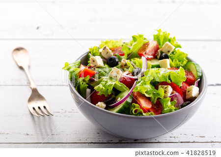 Fresh greek salad served in bowl with fork. Fresh greek salad served in bowl with fork. 41828519