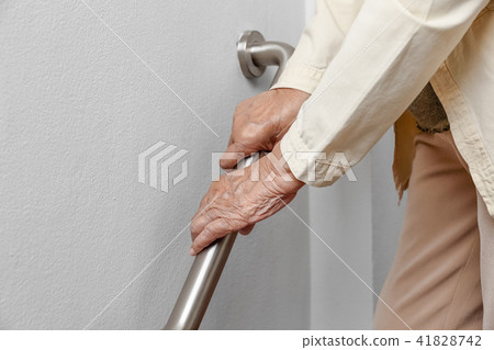 Elderly woman holding on handrail for safety walk Elderly woman holding on handrail for safety walk 41828742