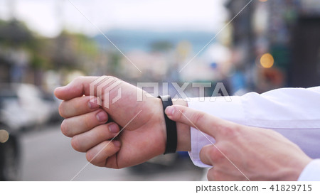 Close up of man hands use smartwatch on street content touch display communication business 41829715