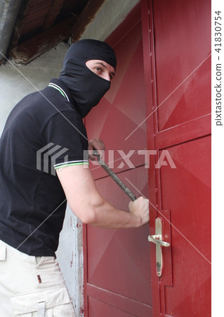 Car thief trying to break into a storage 41830754