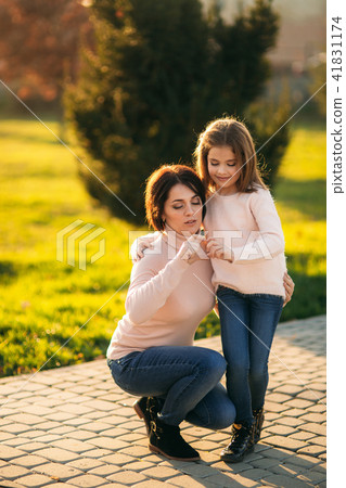 Little girl with mother dressed in blouse walking in the park in autumn. Golden autumn. 41831174